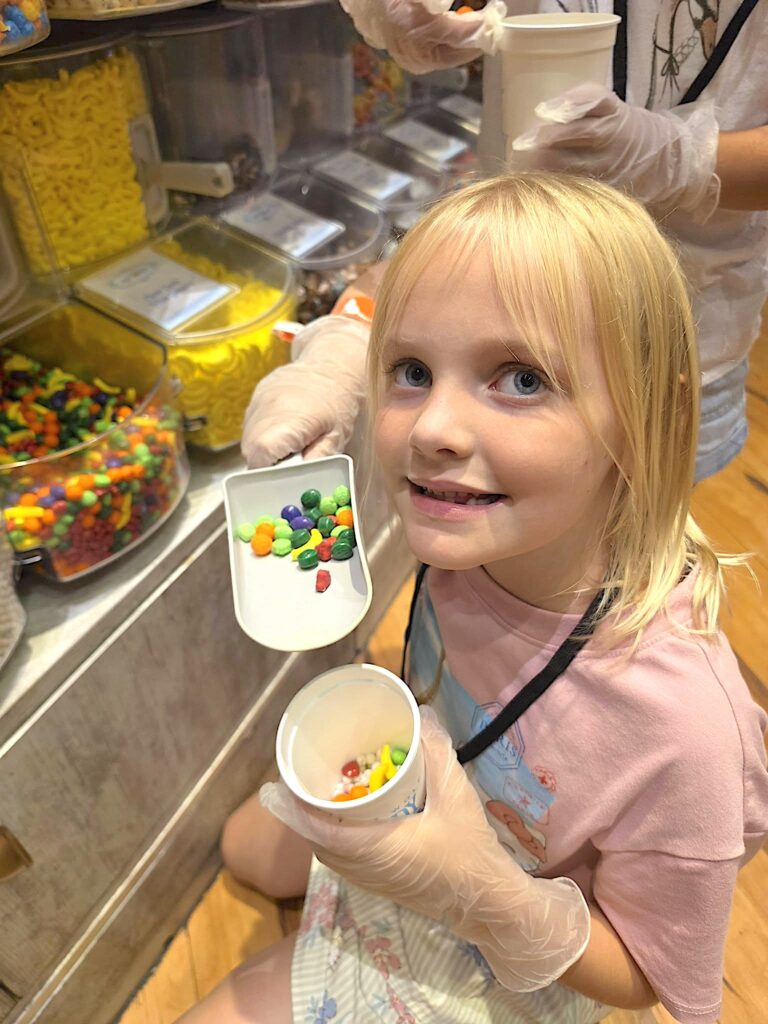 Kids filling their Candy Cups with colorful candy as part of the Great Wolf Lodge Wolf Pass experience.