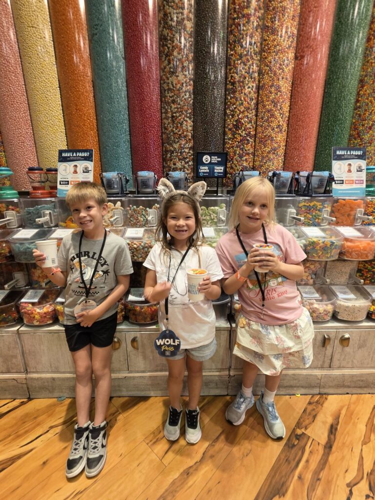 Happy kids showing off their candy in their Candy Cups while exploring Great Wolf Lodge with a Wolf Pass.